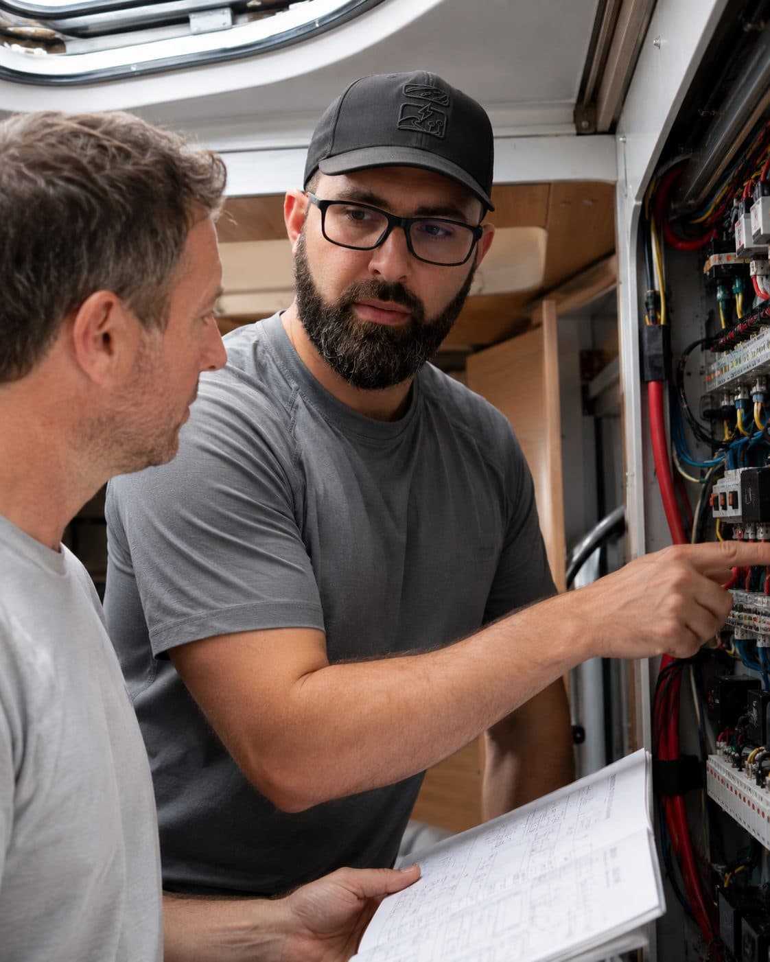 Fabien accompagne un client sur son installation électrique, devant un tableau ouvert